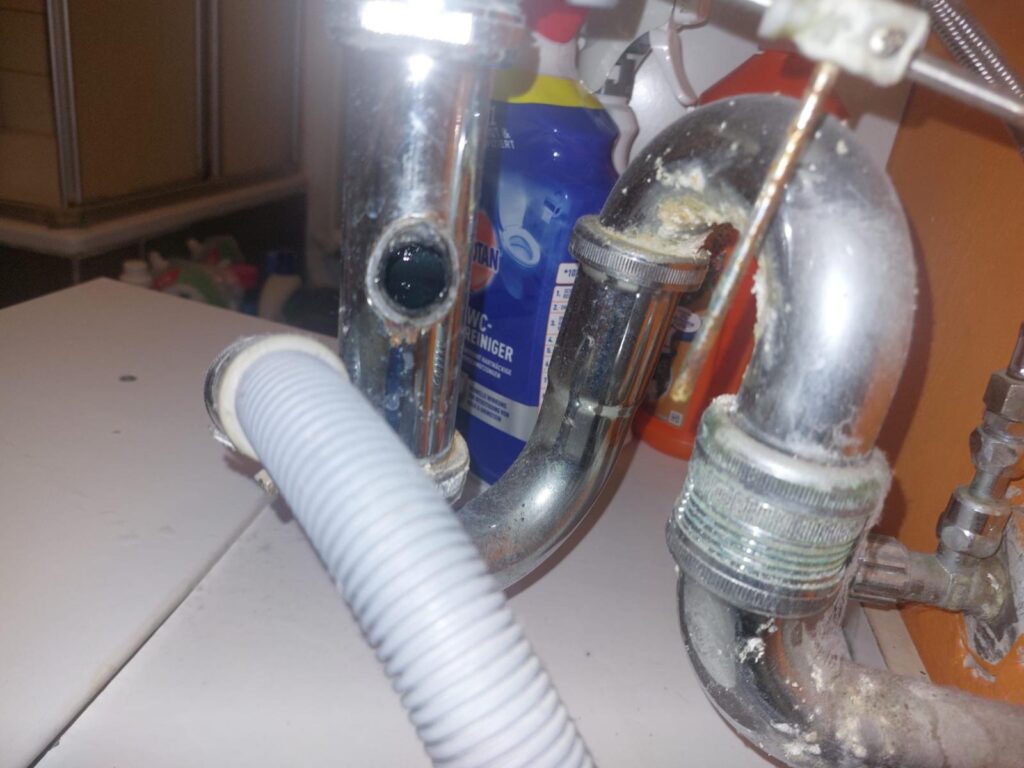 Siphon unter einer Spüle mit angeschlossenem Ablaufschlauch