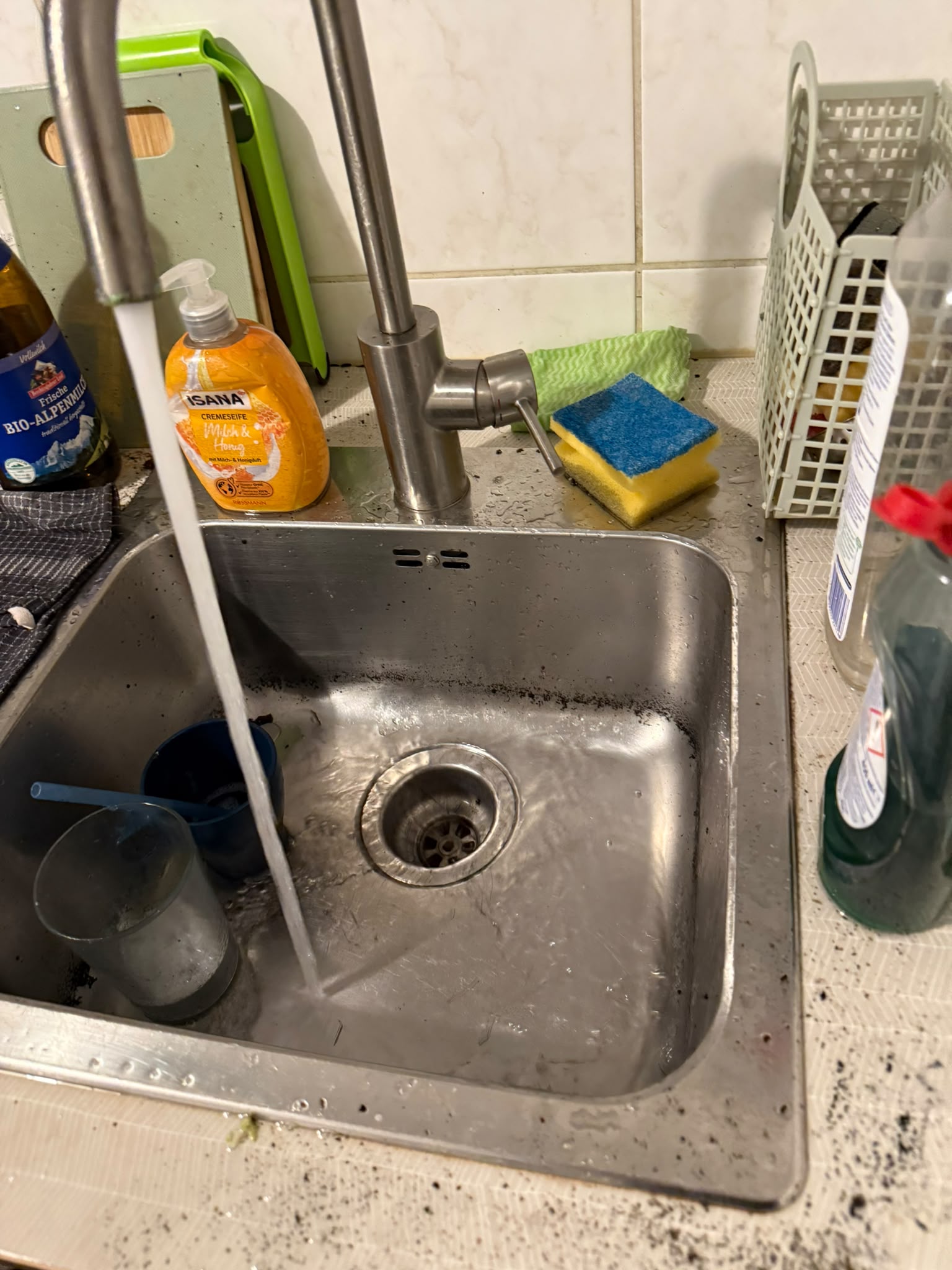 Verstopfte Edelstahlspüle mit stehendem Wasser in der Küche