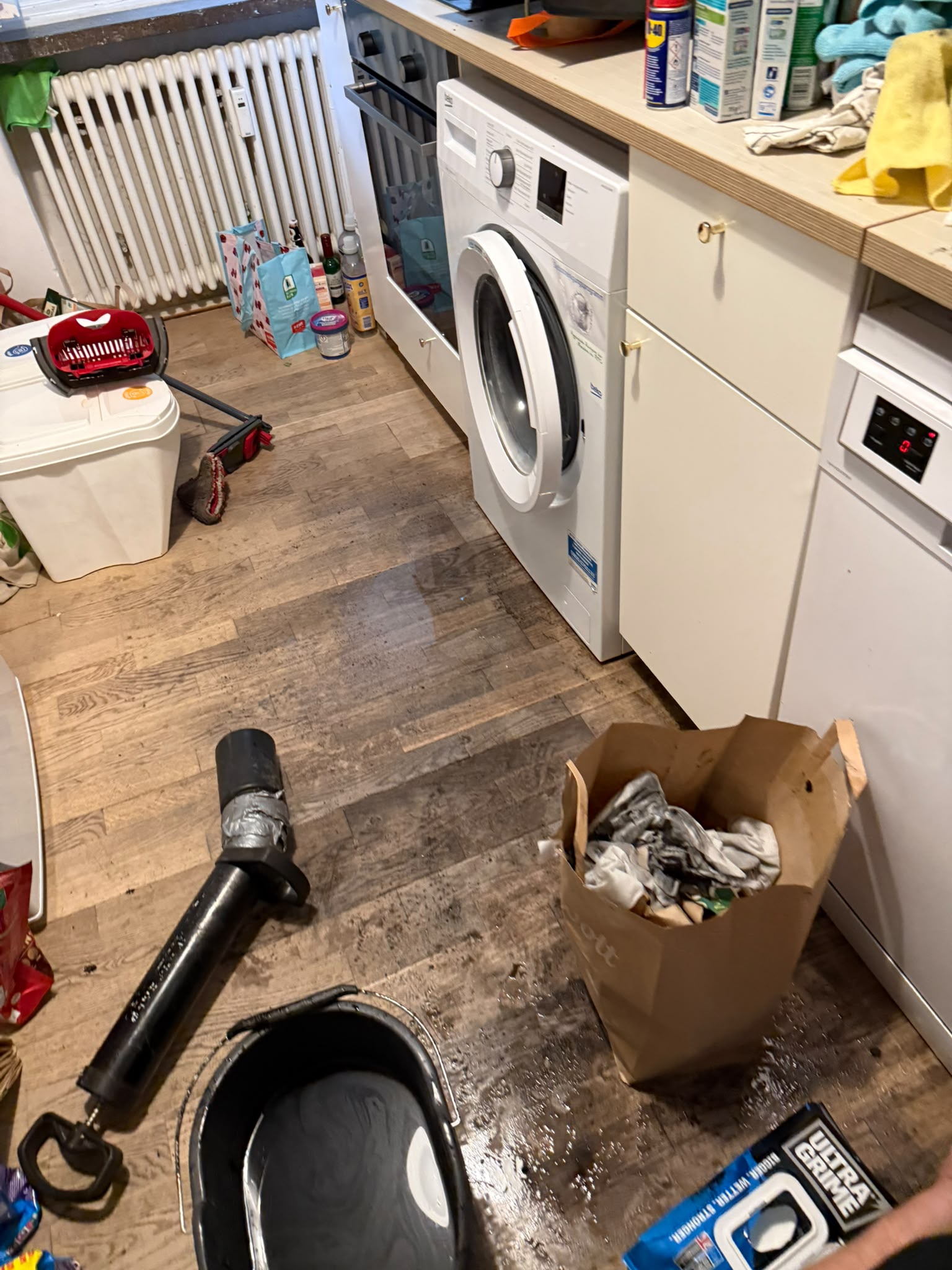 Küche während eines Einsatzes mit ausgebautem Abflusszubehör und Arbeitsgeräten auf dem Boden